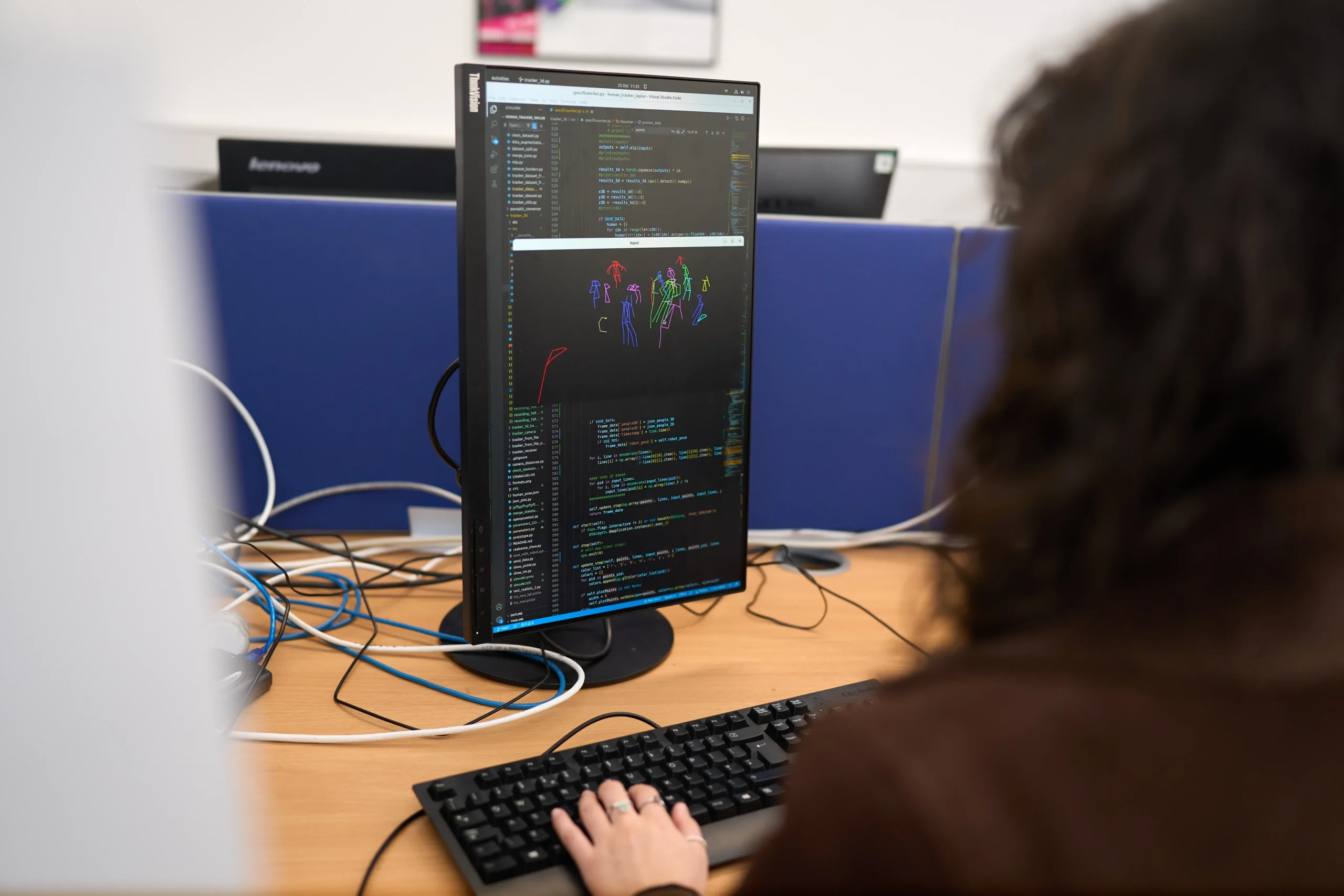 Cybersecurity in the age of AI – threats and solutions - over the shoulder shot of woman looking at computer screen with hands on keyboard