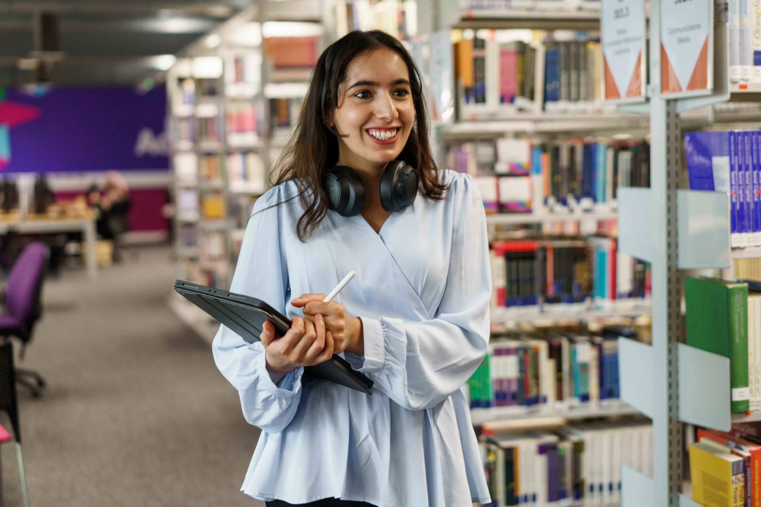 Secure payment options through Flywire - woman holds tablet while smiling in an administrative setting