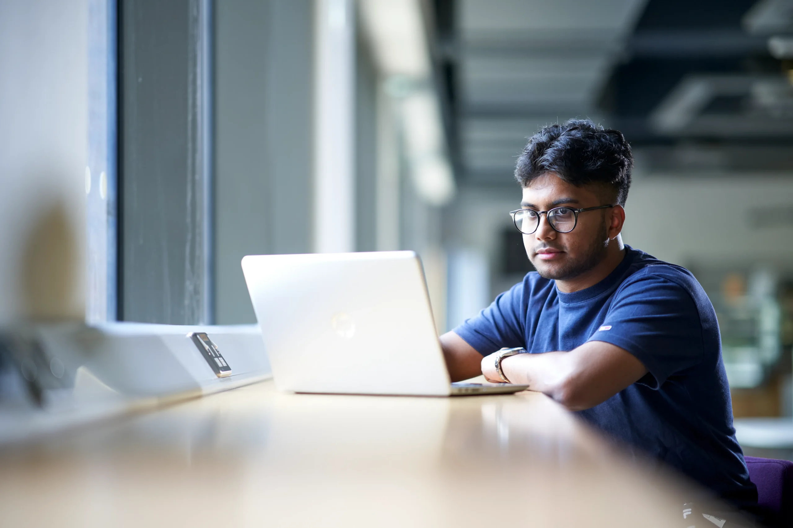 Fundamental cybersecurity practices – Protecting yourself and your organisation - man in blue shirt working at laptop on counter desk