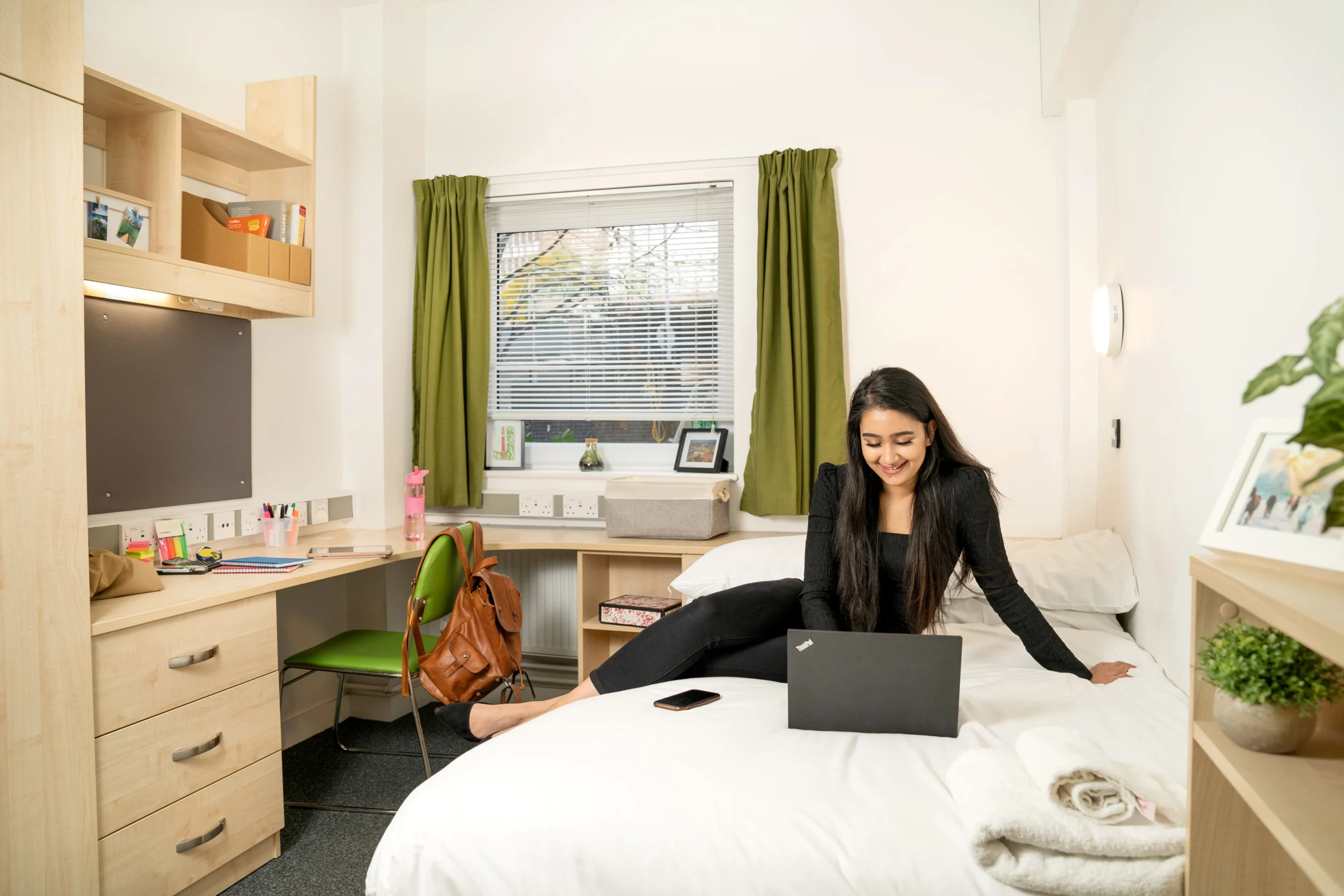 Merit scholarship - smiling woman interacting with laptop