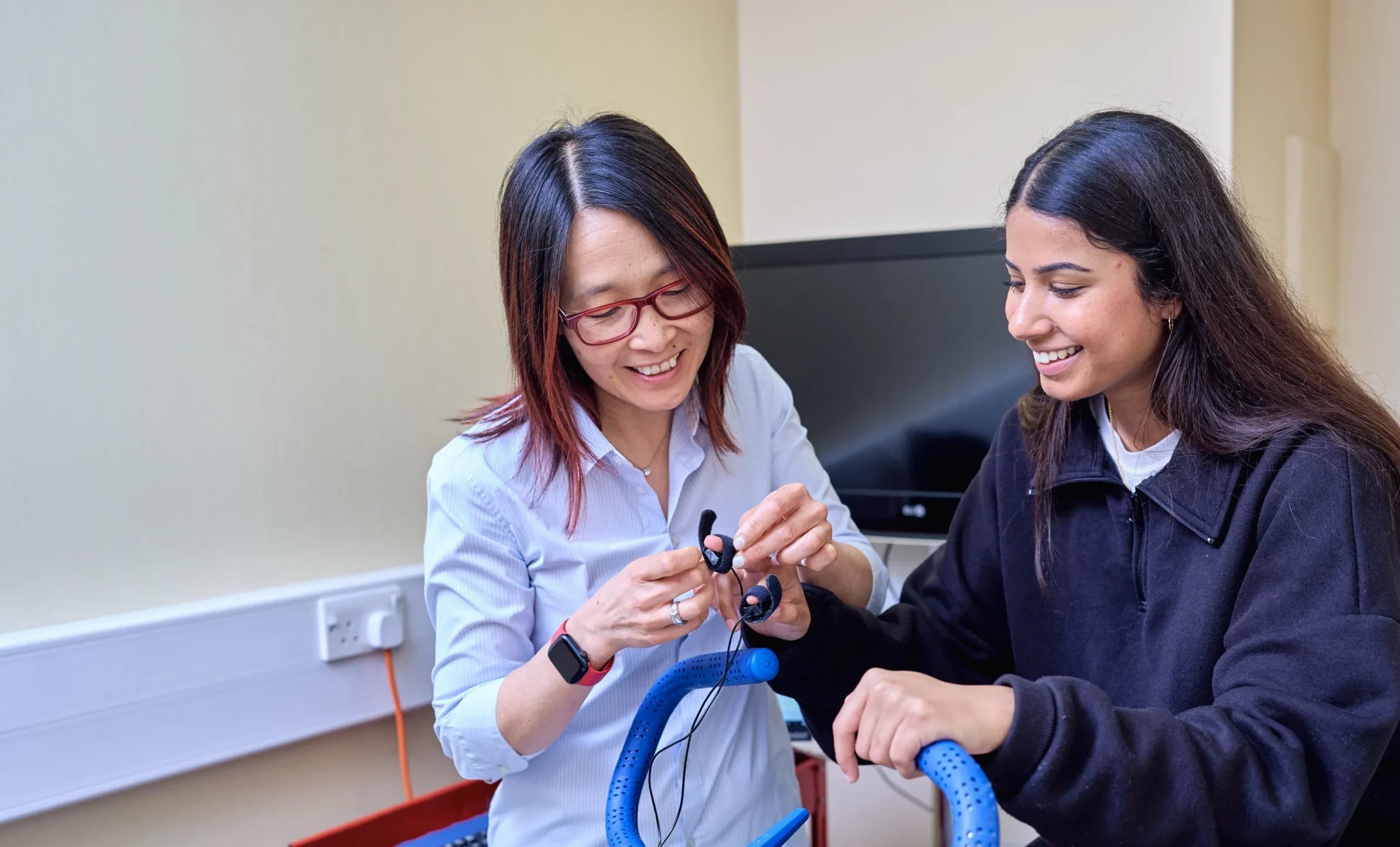 Psychology BSc Aston Online - a woman places a monitor on a womans finger