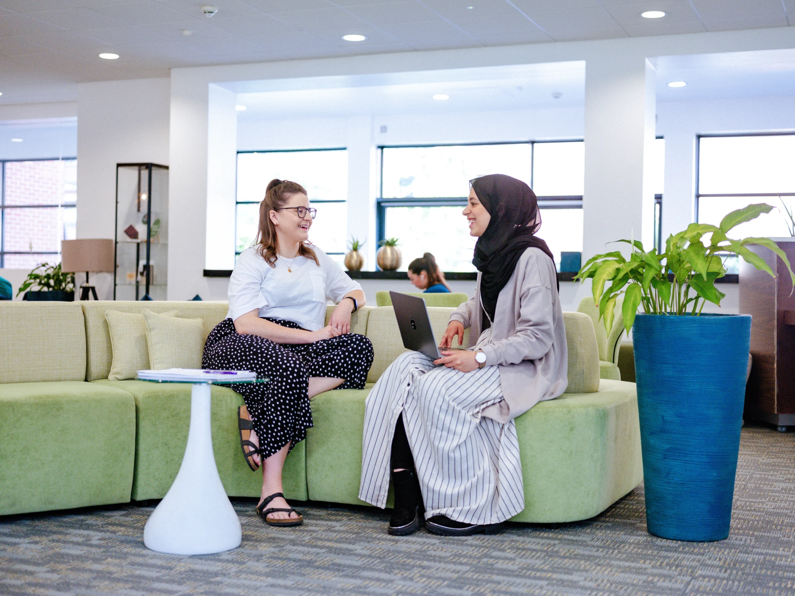 Triple Crown accreditation awarded to Aston Business School - two woman have meeting on green couch