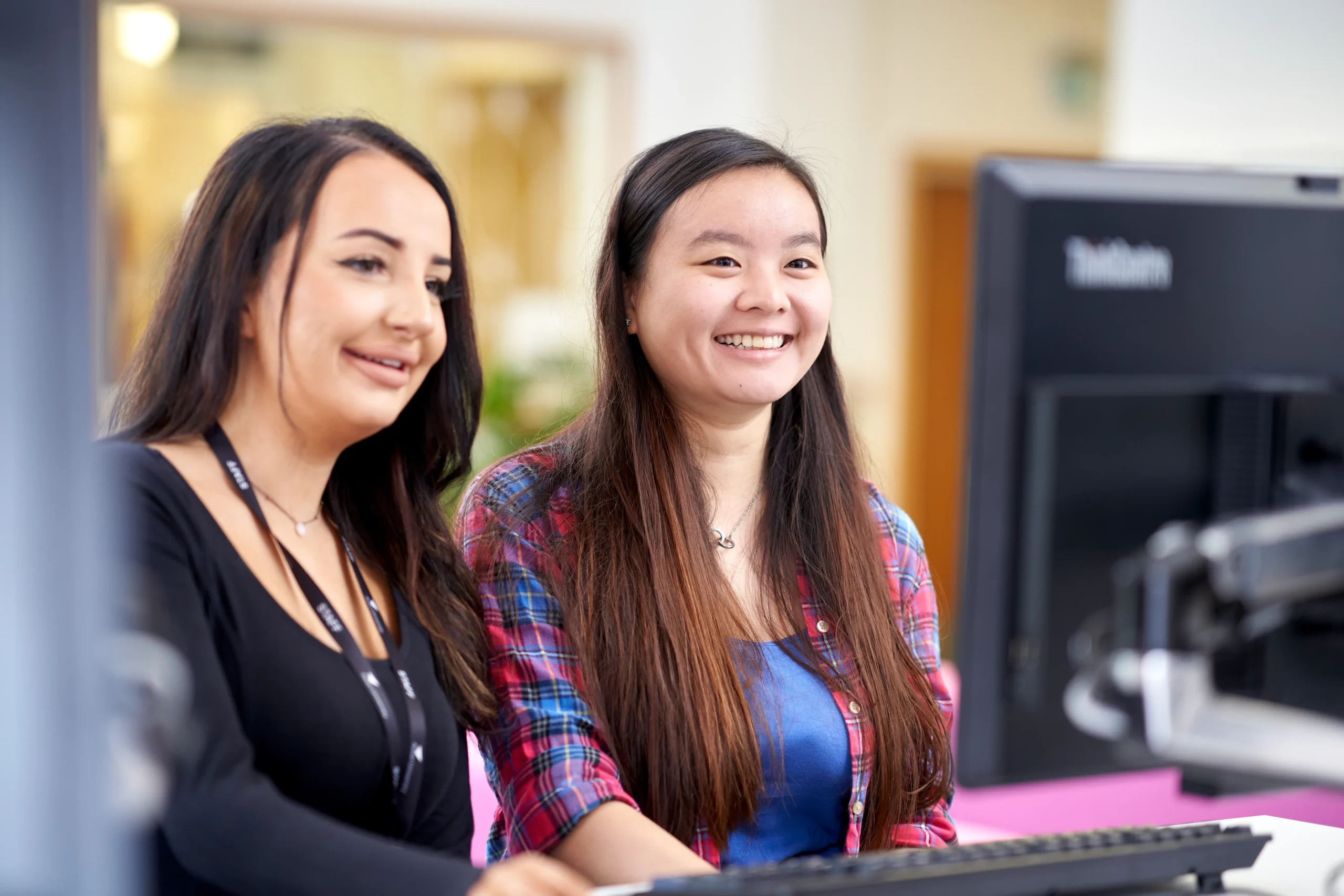 Unlock your potential: Career path options with a business degree - two women working together smiling at a shared screen