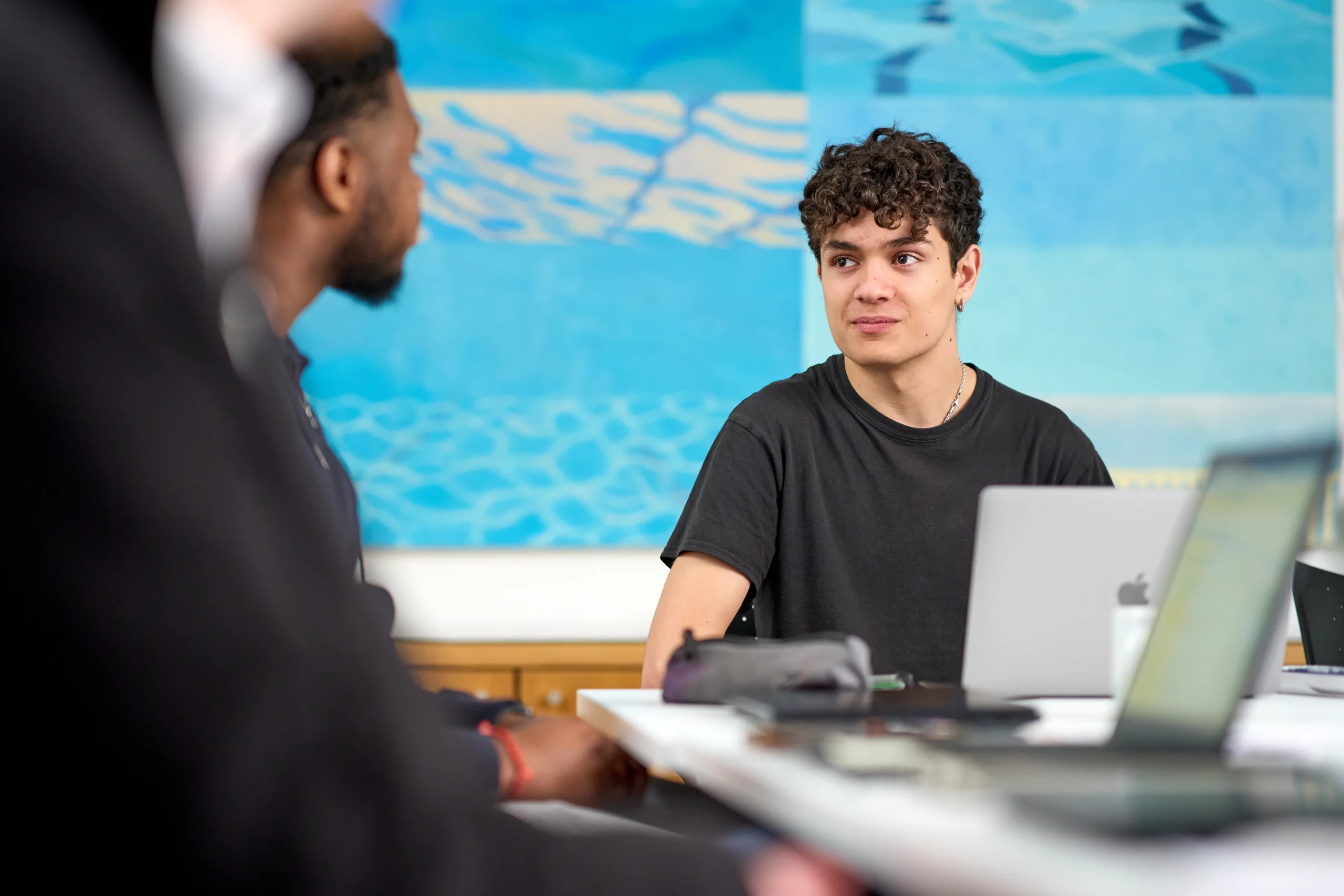Unlock your potential: Career path options with a business degree - two men at table in co-working office on laptops