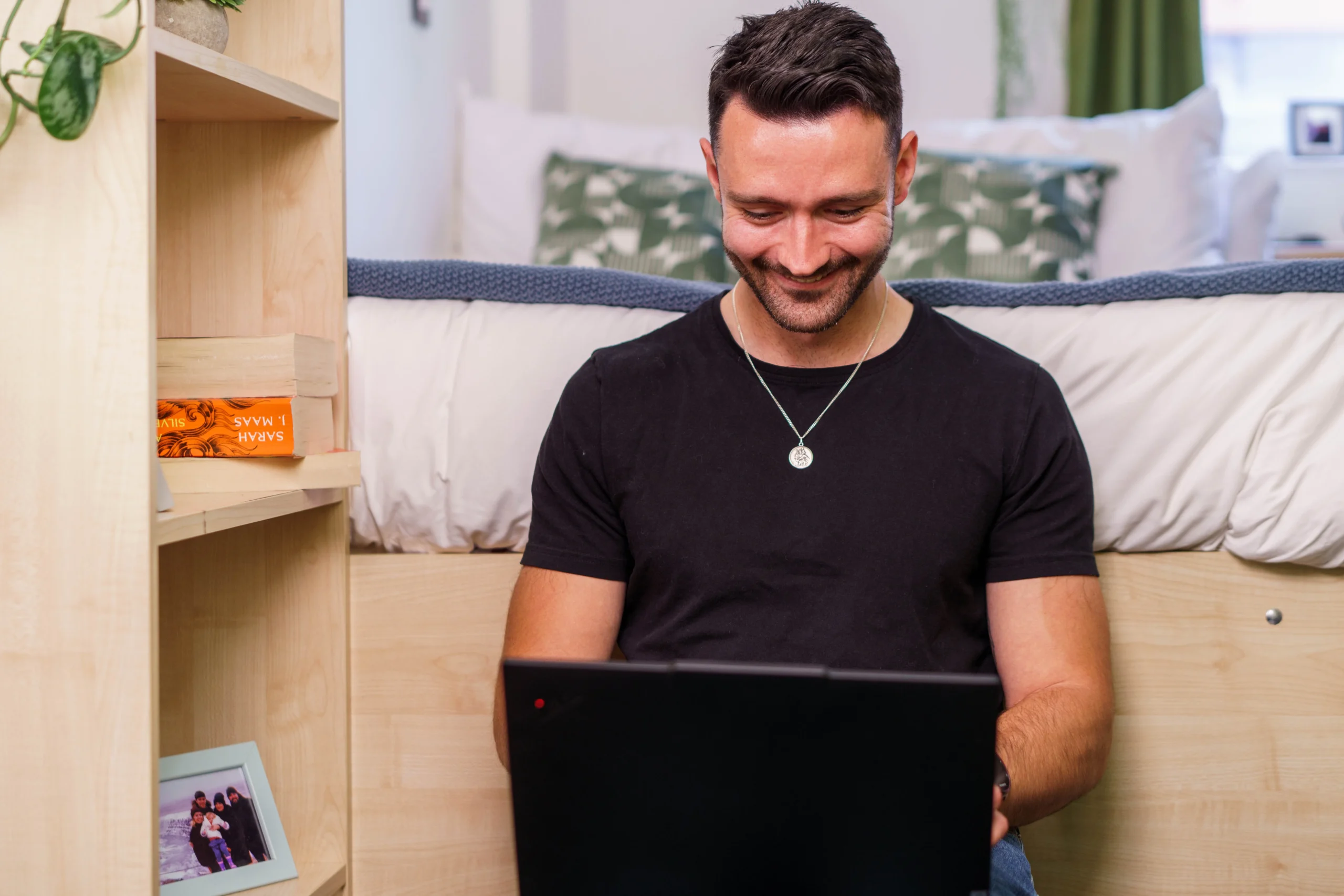 Aston Online - man smiling at laptop, working from home