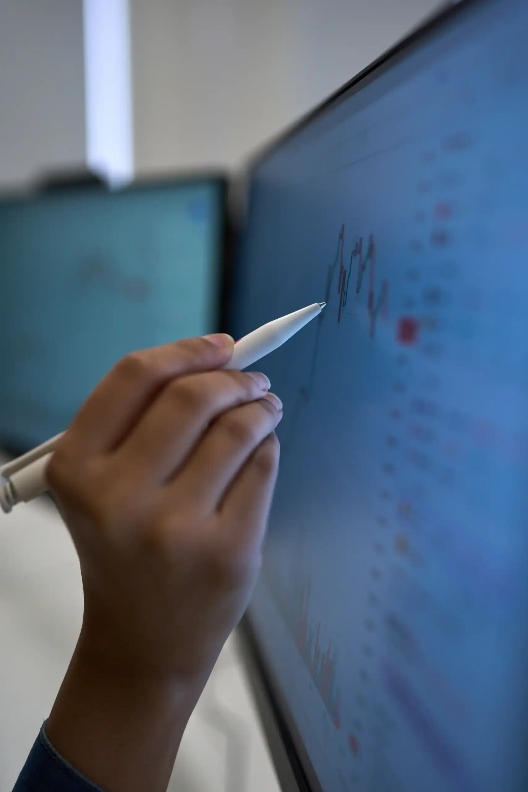 Business Analytics MSc Career Prospects - hand holding pen pointing to data graph on screen