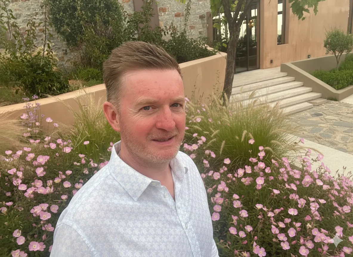 Declan Meagher - Aston Online BSc Student standing in front of a bush of flowers