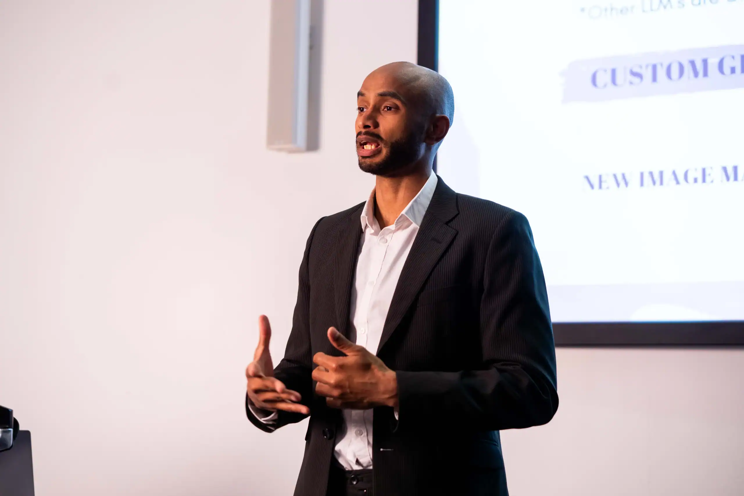 Doctor of Business Administration: The benefits of professional doctoral study - man in shirt and blazer giving lecture in front of a screen
