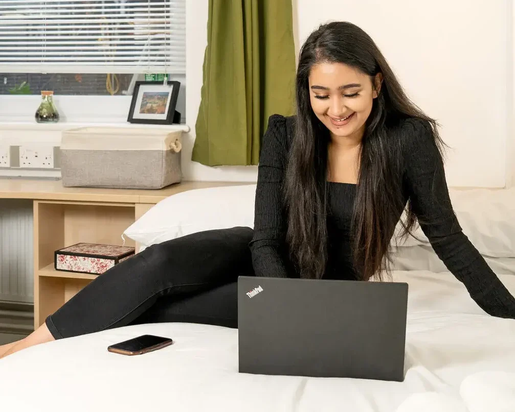 Online Degree Programmes - Aston University Online - woman smiling while working on laptop