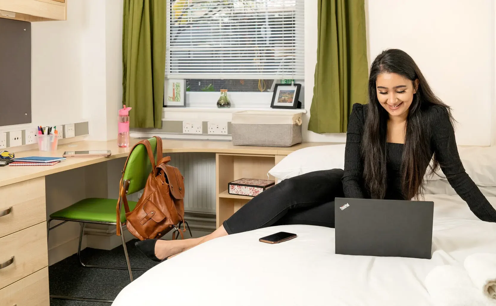 Online Degree Programmes - Aston University Online - woman smiling while working on laptop