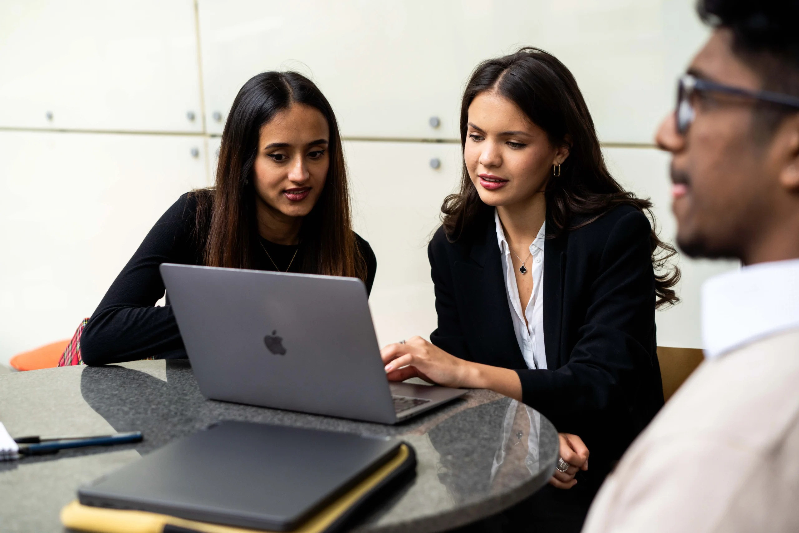 How technology is changing legal careers - Three professional looking people work around one laptop in an office