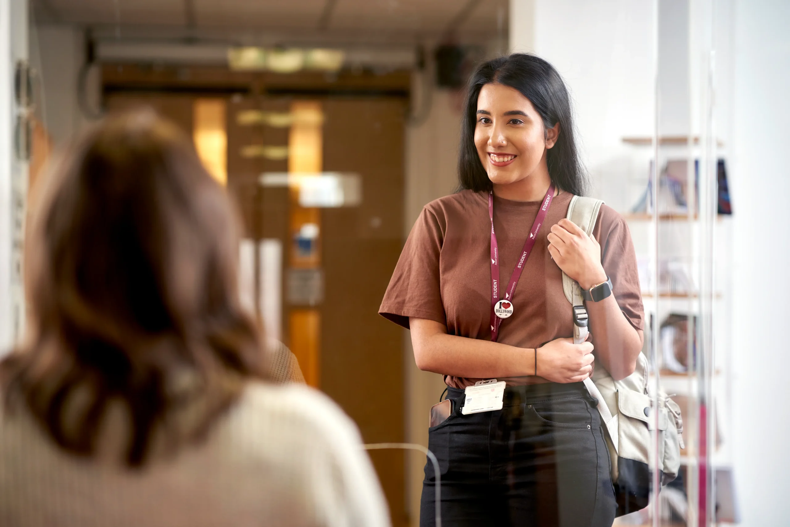 Aston Online blog - How to become a cybersecurity professional with no coding experience - woman smiling holding backpack