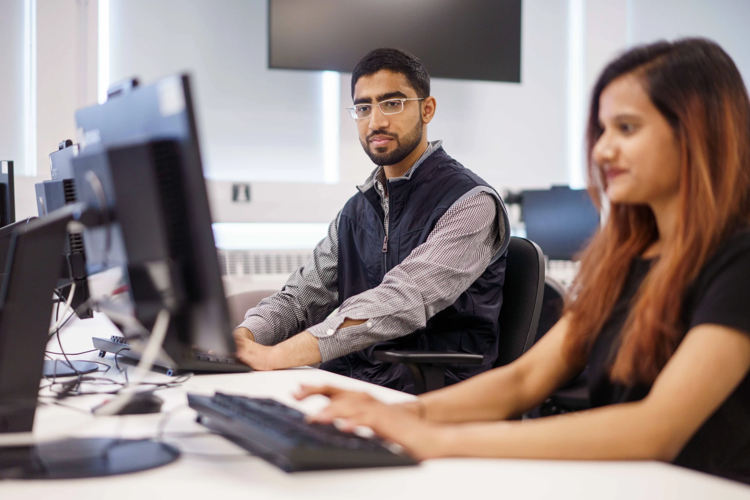 How to become a data scientist - man and woman at desk looking at a second screen.