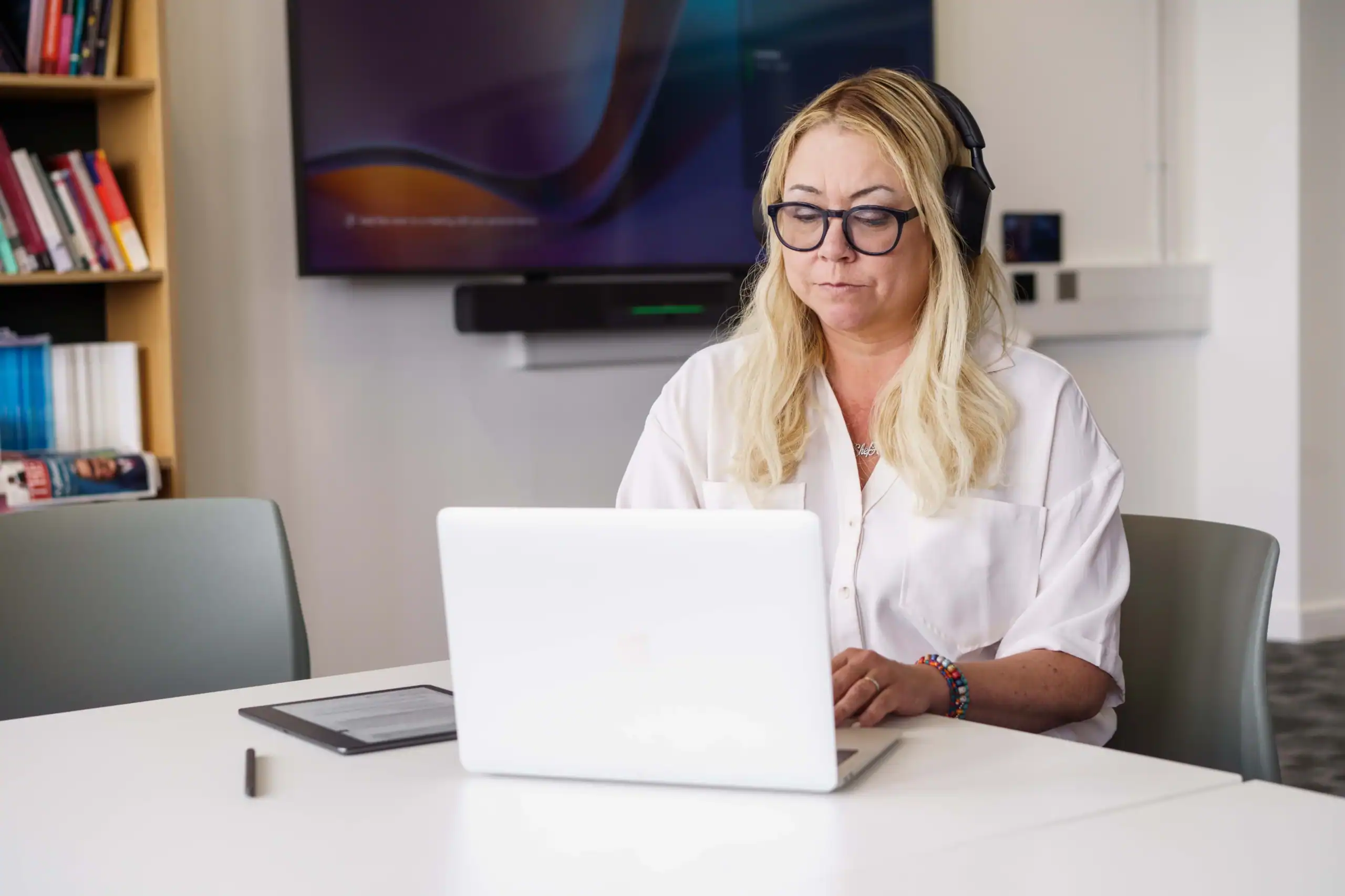 The rising demand for DBAs - blonde women with glasses and headphones working at laptop
