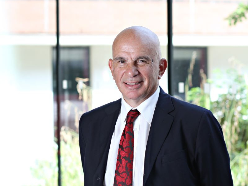 Dr Geoff Parkes - Aston Online DBA Progranne Director smiling wearing a suit