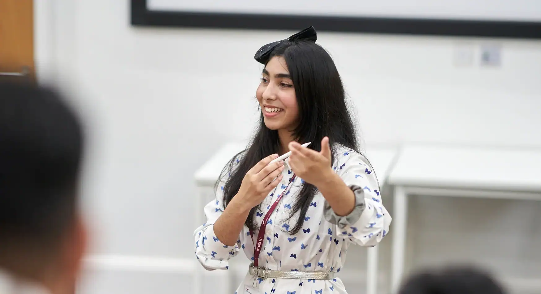 Study at Aston Online - woman pointing to download brochure on the right